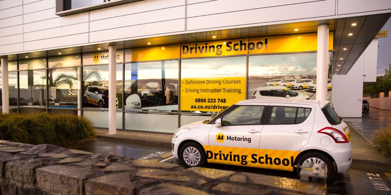 AA Motoring Driving School vehicle parked in front of AA Driving School building