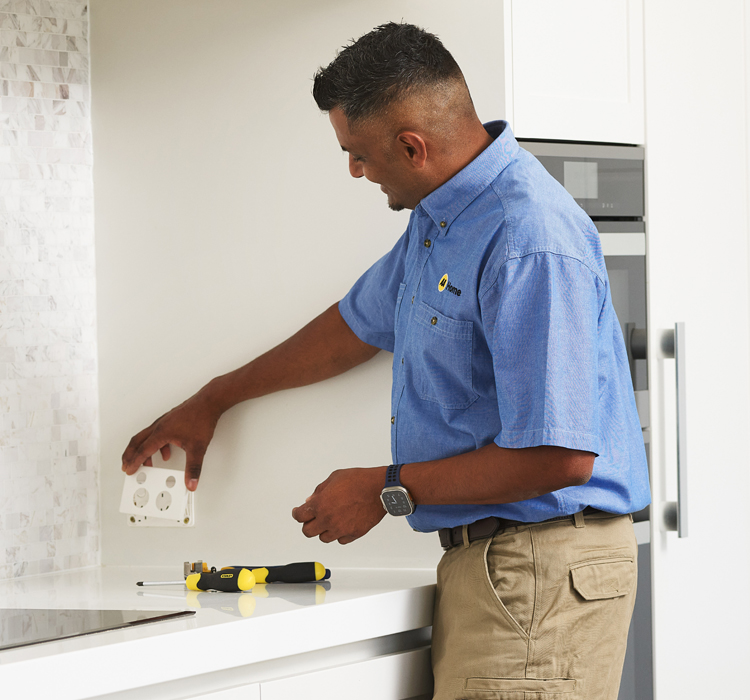 Electrician working on a kitchen outlet