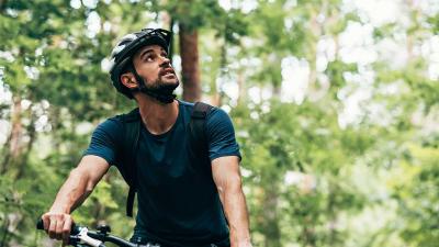 A man riding a bike through bush trail