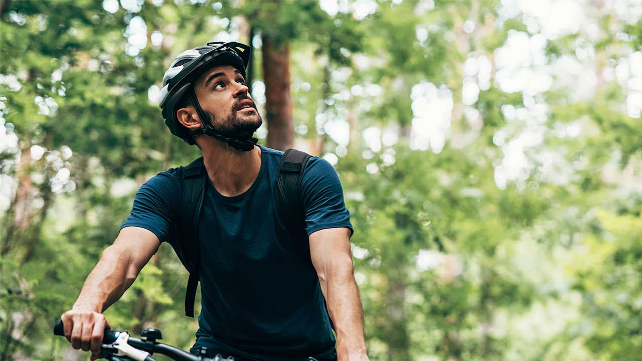 A man riding a bike through bush trail