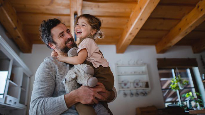 Dad holding his young daughter and stuffed animal