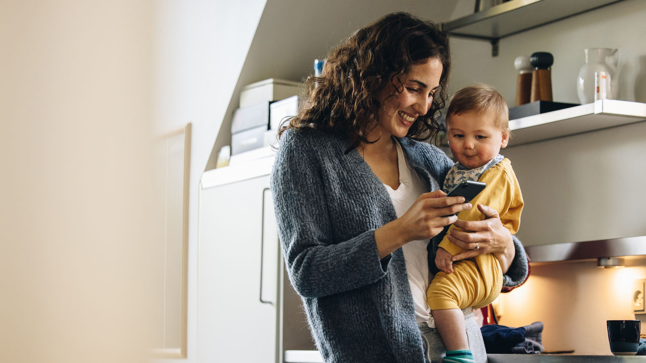 Mum holding baby in kitchen