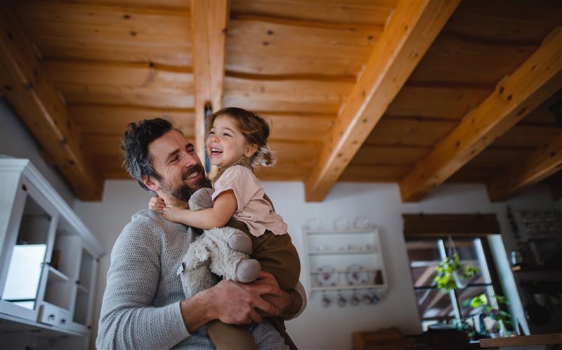 Dad holding his young daughter and stuffed animal