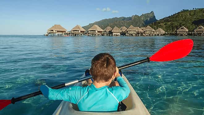 Boy kayaking on a tropical beach