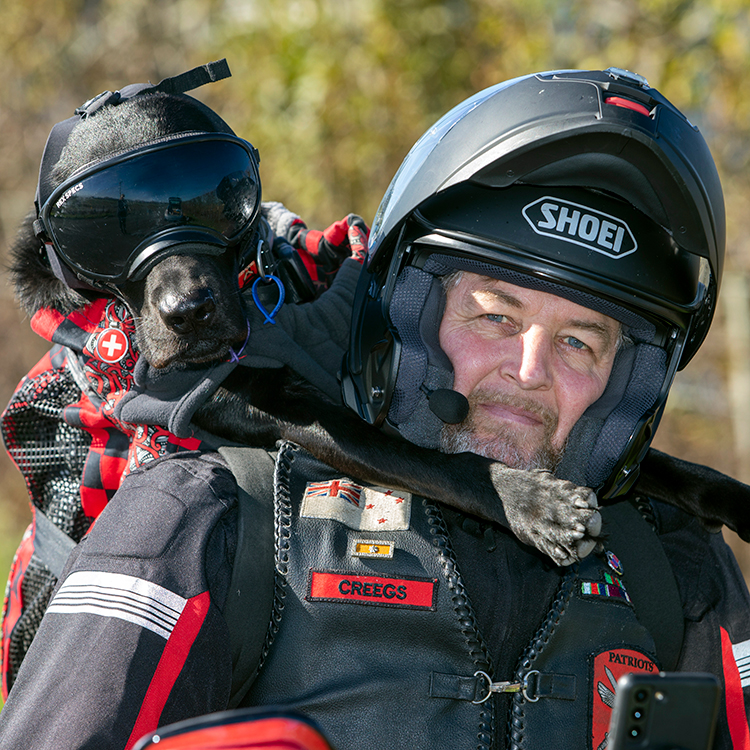 Loki loves riding on the motorbike with Stevin. Photo by Tim Cuff.
