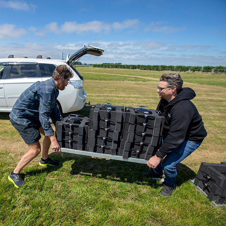 The team does the heavy lifting to get drones into position. Photo by Tim Cuff.