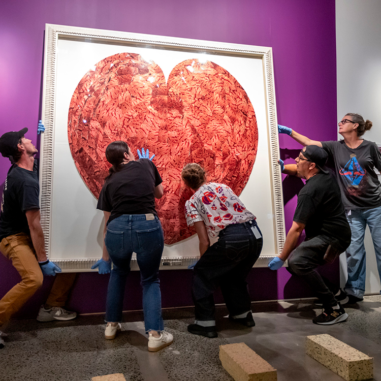 Hanging a large artwork for the Slow Burn exhibition. Photo by Maarten Holl.