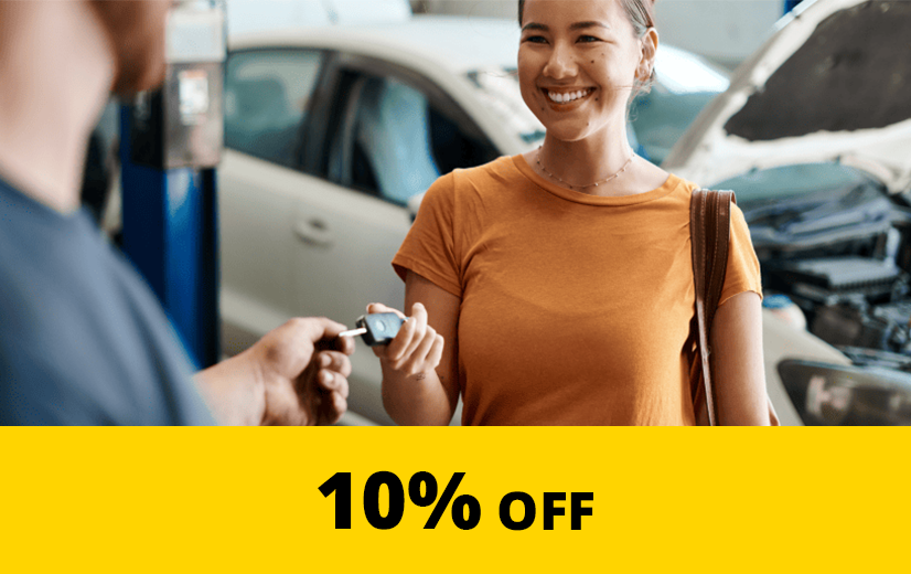 Young woman being handed her keys at a mechanic