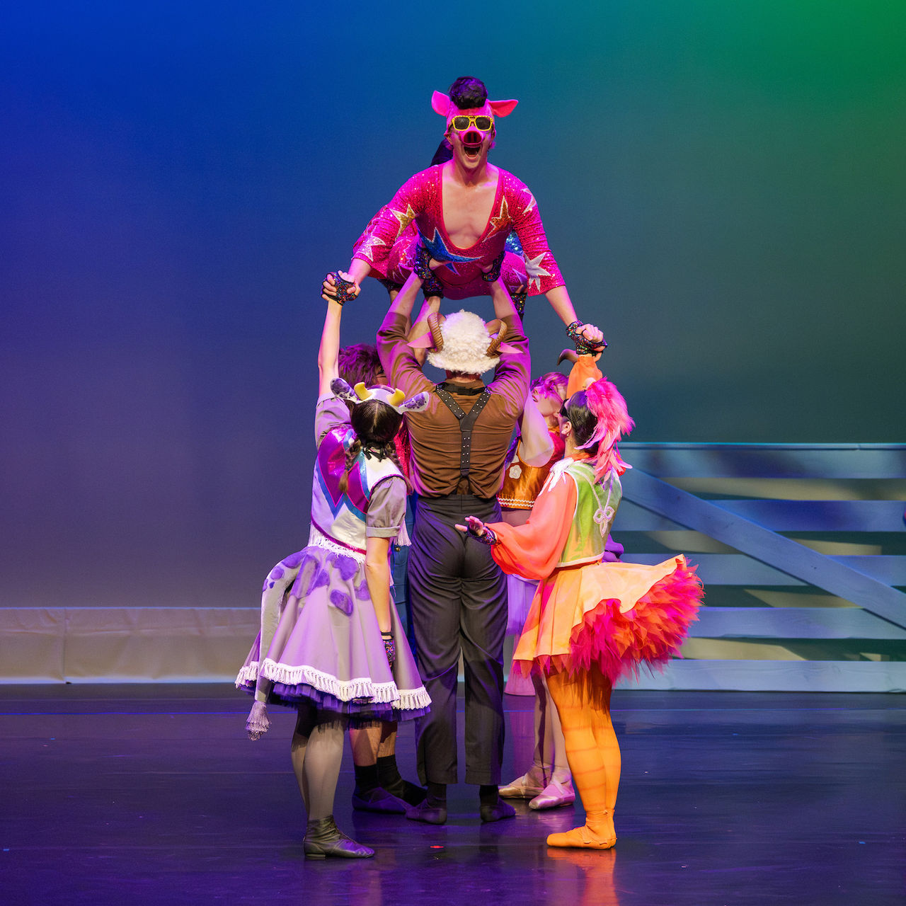 Ballet dancers in eccentric barnyard animal costumes posed on stage