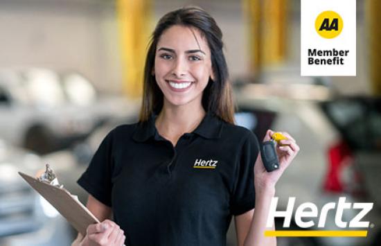 Young woman in a Hertz staff polo holding up car keys in one hand and a clipboard with the other.