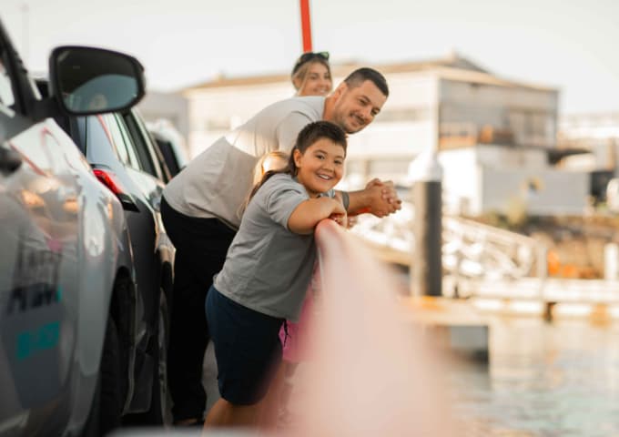 Travellers enjoying the view from the vehicle deck of a SeaLink ferry during a Hauraki Gulf crossing.