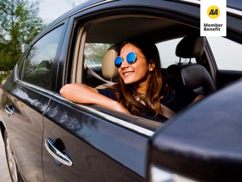 Woman smiling out the rolled down window of the car.